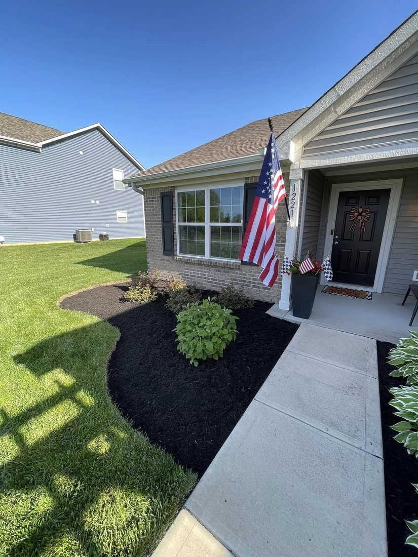 Fresh mulch beds and shrubs framing a home's front entry