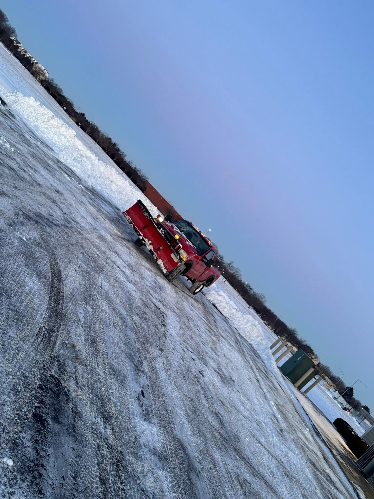 Plow truck clearing a snow-covered lot