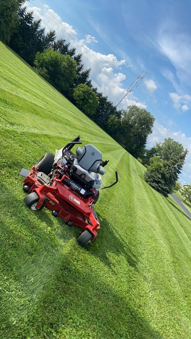 Zero-turn mower cutting fresh stripes into a green lawn